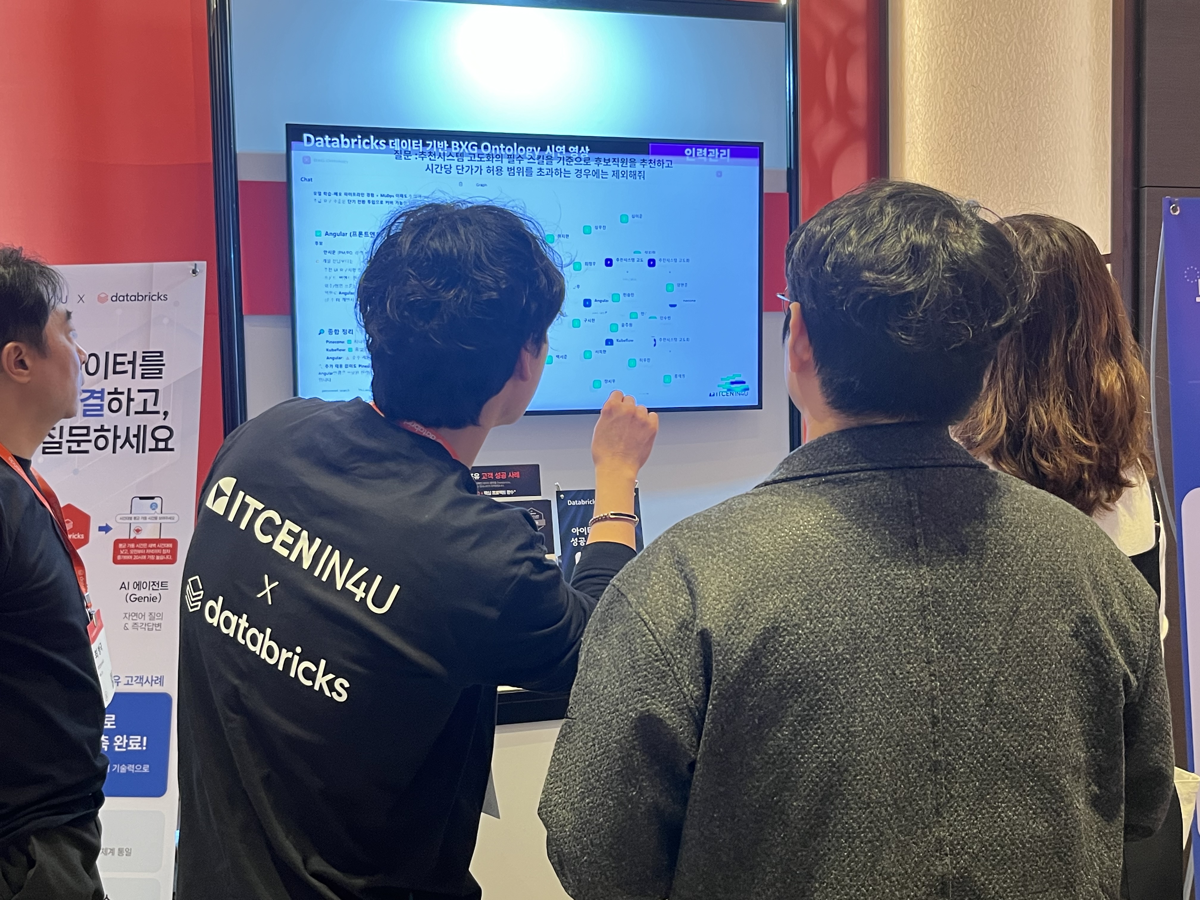 아이티센인포유 엔지니어가 &lsquo;데이터브릭스 AI 데이 2026&rsquo; 현장에서 방문객에게 온톨로지 기반의 BXG 플랫폼 시연을 통해 데이터 분석 과정을 설명하고 있다.